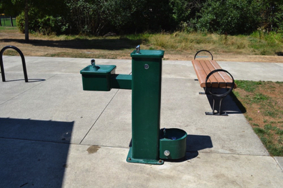 Drinking fountain, bench and bike rack approaching paved perimeter trail